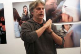 Ein Mann mit grauen Haaren spricht vor den Bildern der "Schönheit der Blinden". Er gestikuliert